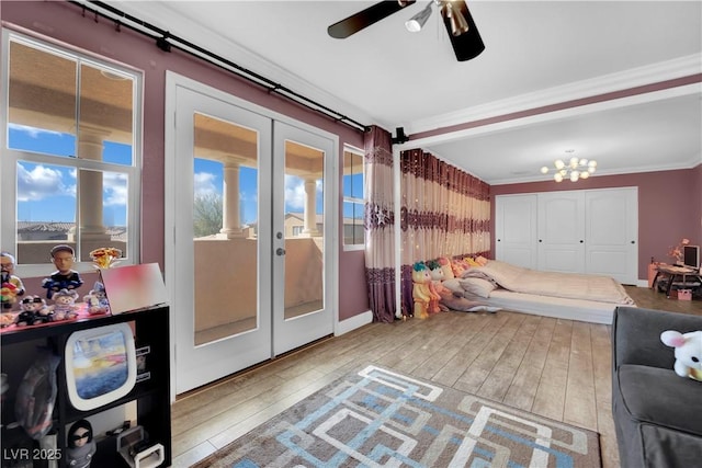 interior space with ornamental molding, french doors, a chandelier, and light wood-style flooring