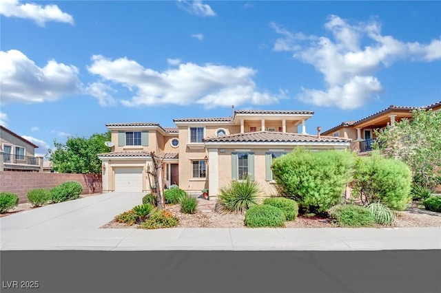 mediterranean / spanish house featuring an attached garage, fence, driveway, a tiled roof, and stucco siding