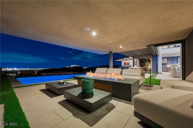 patio terrace at dusk with an outdoor living space with a fire pit