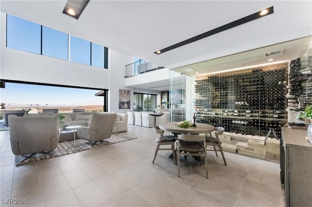 interior space with light tile patterned floors, a high ceiling, and visible vents