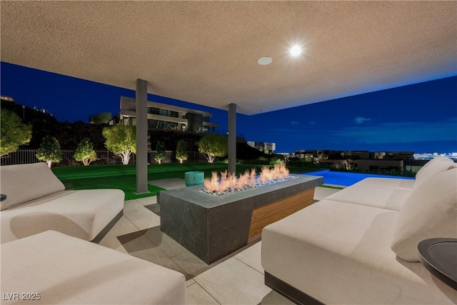 patio at twilight featuring an outdoor living space with a fire pit