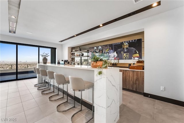 bar with indoor wet bar and light tile patterned floors