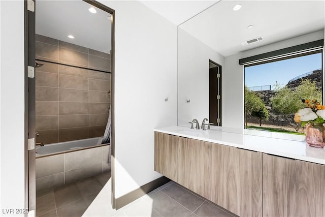 full bath featuring tile patterned flooring, recessed lighting, vanity, visible vents, and tiled shower / bath