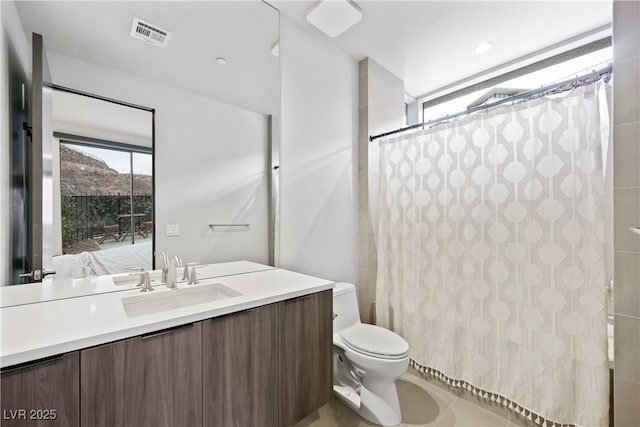 bathroom featuring toilet, visible vents, a shower with shower curtain, and vanity