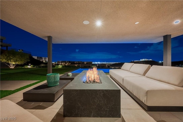 patio at twilight with an outdoor living space with a fire pit