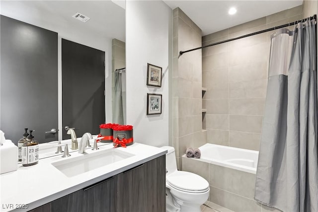 bathroom featuring tiled shower / bath, toilet, visible vents, and vanity