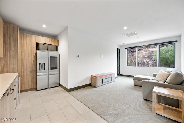 living room featuring recessed lighting, light carpet, and baseboards