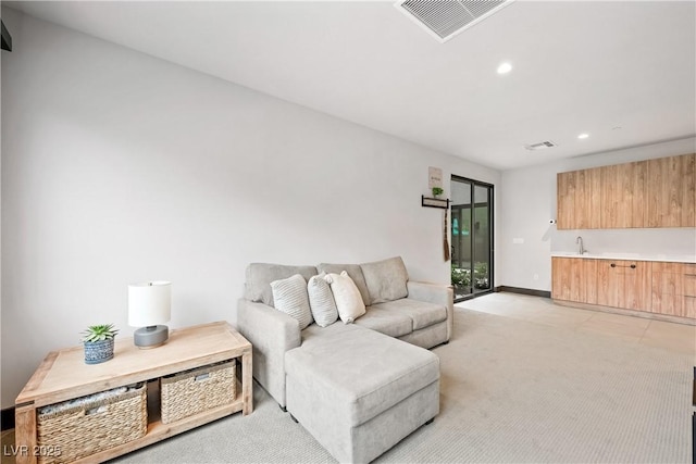 living area featuring light carpet, baseboards, visible vents, and recessed lighting