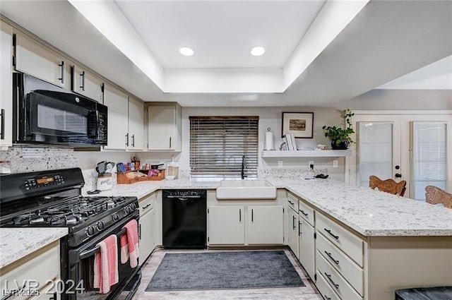 478 Potomac St, Henderson, NV 89015 - kitchen featuring a peninsula, a sink, french doors, black appliances, and a tray ceiling