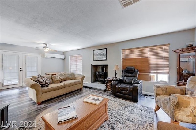 478 Potomac St, Henderson, NV 89015 - living area with a textured ceiling, a wall unit AC, wood finished floors, visible vents, and french doors