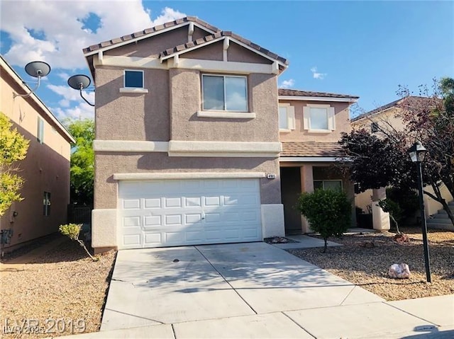 view of front facade with an attached garage, driveway, and stucco siding