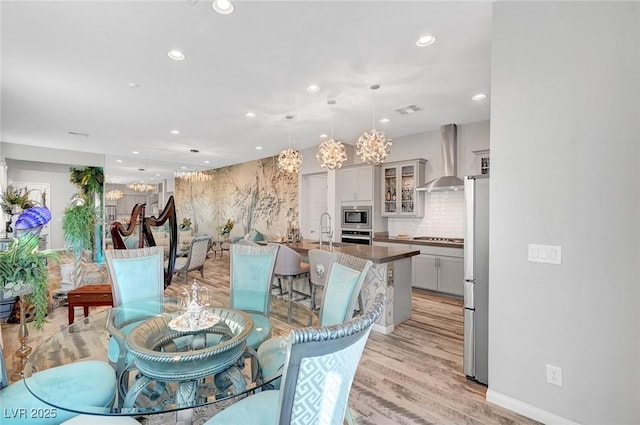 dining room featuring recessed lighting, visible vents, a notable chandelier, and light wood-style flooring