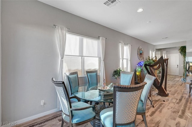 dining room featuring light wood finished floors, visible vents, and baseboards