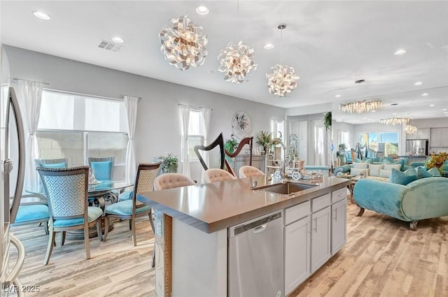 kitchen with an inviting chandelier, light wood-style flooring, stainless steel appliances, and open floor plan