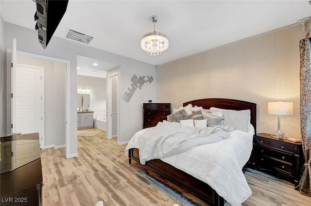 bedroom featuring visible vents, baseboards, light wood-style flooring, ensuite bathroom, and an inviting chandelier