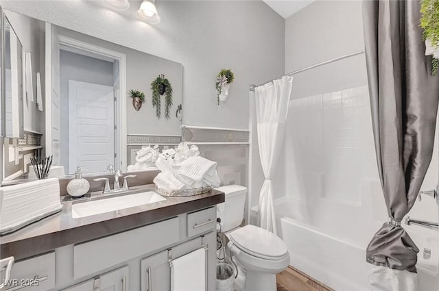 bathroom featuring shower / tub combo with curtain, vanity, toilet, and wood finished floors