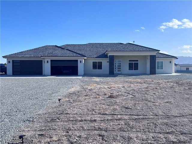 view of front of property with a garage, driveway, and stucco siding