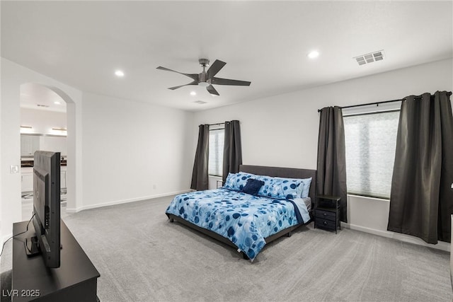 bedroom with carpet floors, arched walkways, recessed lighting, visible vents, and baseboards