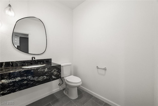 bathroom featuring tile patterned flooring, baseboards, vanity, and toilet