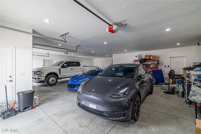 garage with recessed lighting and a garage door opener