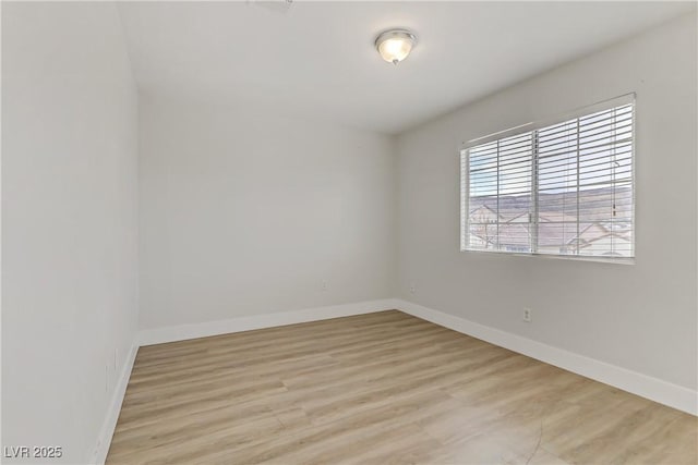 unfurnished room featuring light wood-type flooring and baseboards