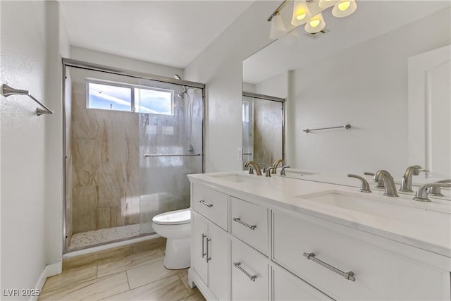 full bathroom with a sink, a shower stall, toilet, and double vanity