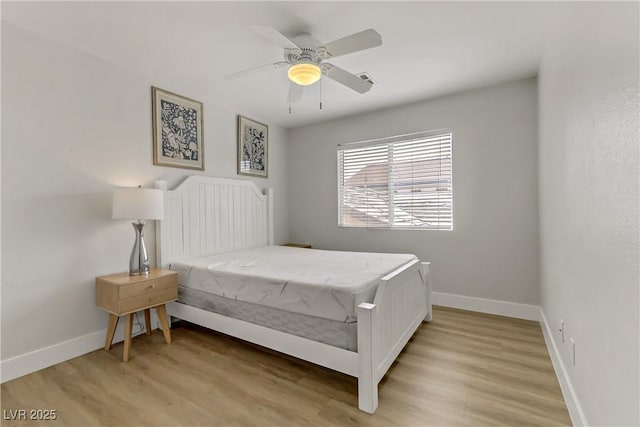 bedroom featuring a ceiling fan, baseboards, and light wood finished floors