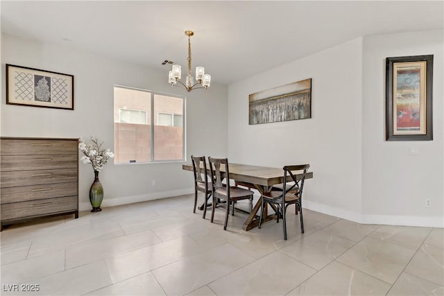 dining space featuring a chandelier and baseboards