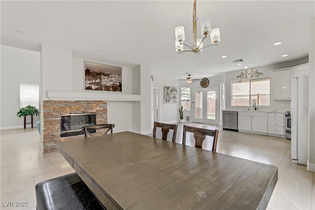 dining room with a fireplace, recessed lighting, a ceiling fan, light tile patterned flooring, and baseboards