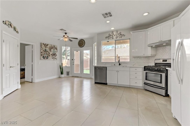 kitchen with visible vents, stainless steel appliances, light countertops, under cabinet range hood, and white cabinetry