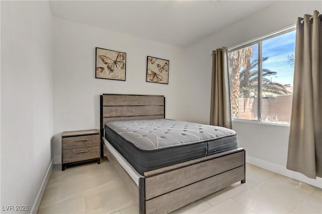 bedroom with baseboards and light tile patterned floors