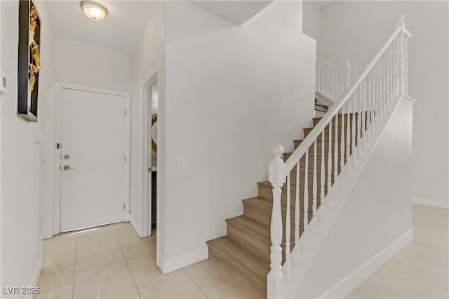 stairway with tile patterned flooring and baseboards