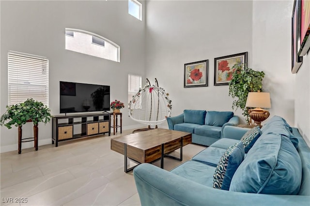 living room with a towering ceiling and baseboards