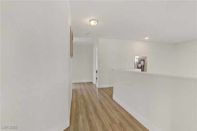 hallway featuring recessed lighting, light wood-type flooring, and baseboards