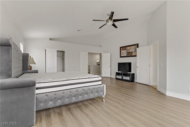 bedroom with lofted ceiling, ceiling fan, and light wood-style flooring