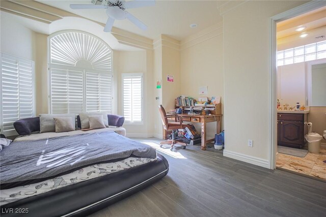 bedroom with ceiling fan, baseboards, wood finished floors, and ensuite bathroom