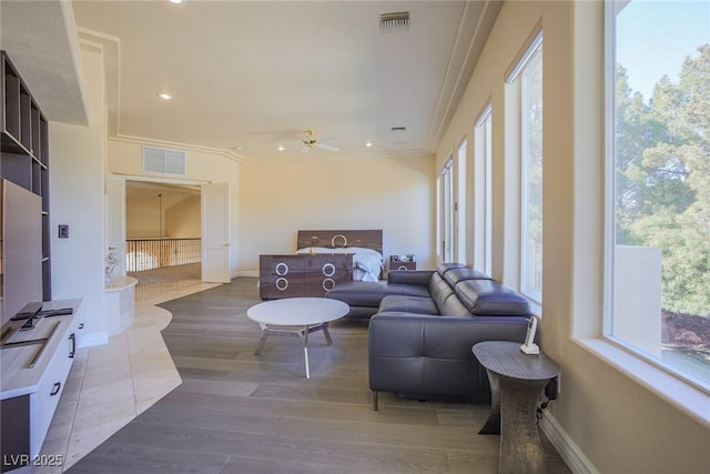 living area featuring baseboards, visible vents, and wood finished floors