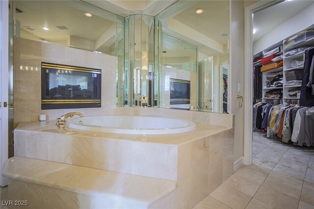 bathroom featuring recessed lighting, a walk in closet, a bath, and tile patterned floors