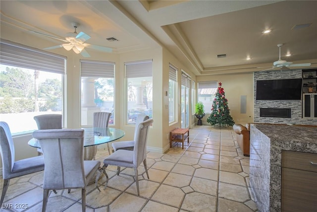 dining space featuring visible vents, a stone fireplace, a ceiling fan, and recessed lighting