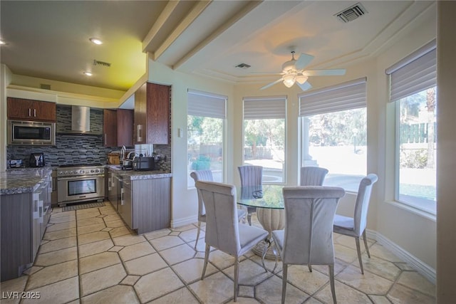 kitchen featuring stainless steel appliances, visible vents, decorative backsplash, and wall chimney exhaust hood