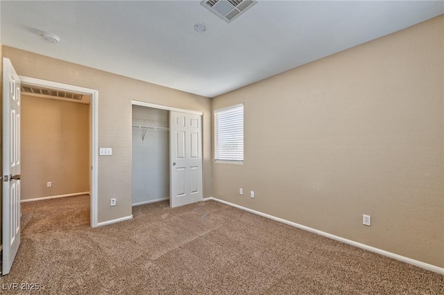 unfurnished bedroom with carpet floors, a closet, visible vents, and baseboards