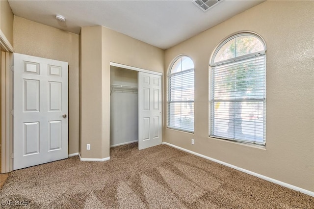 unfurnished bedroom featuring carpet, a closet, visible vents, and baseboards