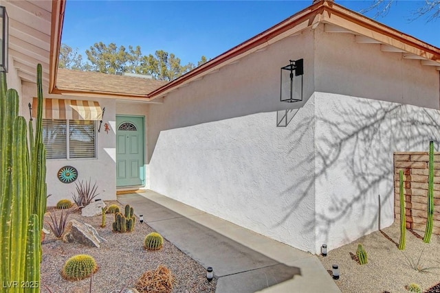 view of exterior entry with stucco siding