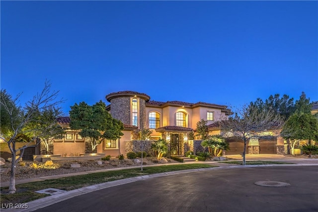 mediterranean / spanish home with a tiled roof and stucco siding