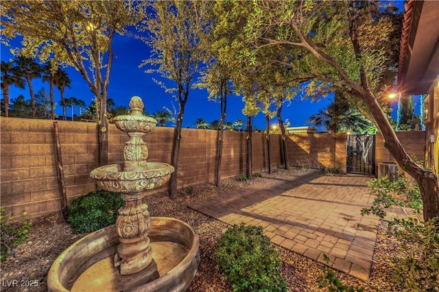 patio at night with a fenced backyard