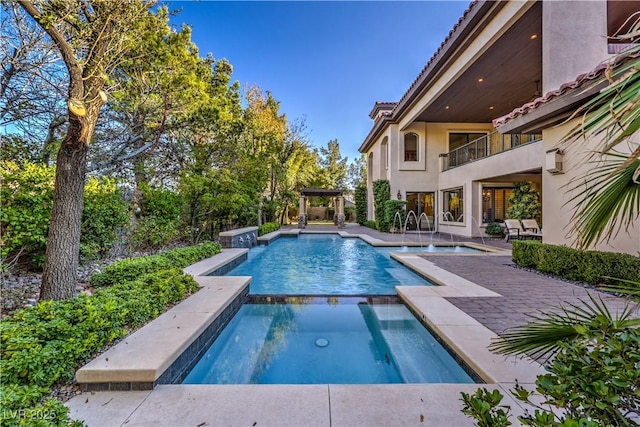 view of swimming pool featuring a pool with connected hot tub and a patio area