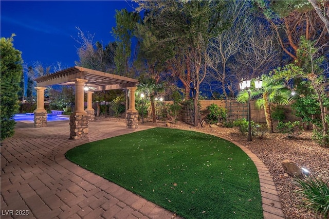 yard at twilight with a patio area, fence, and a pergola