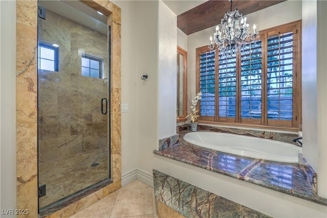 full bath featuring a garden tub, a notable chandelier, baseboards, tile patterned floors, and a stall shower