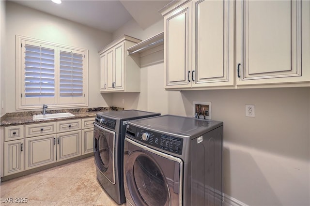 clothes washing area featuring cabinet space, separate washer and dryer, and a sink