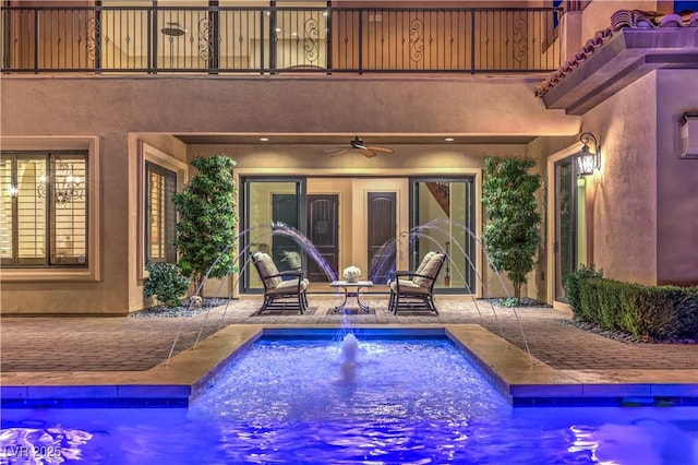 view of swimming pool featuring ceiling fan and a patio